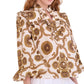 A woman wearing the Cara Cara Elowen Top—a cream long sleeve with brown floral and geometric print, ruffle collar, and flared sleeves.
