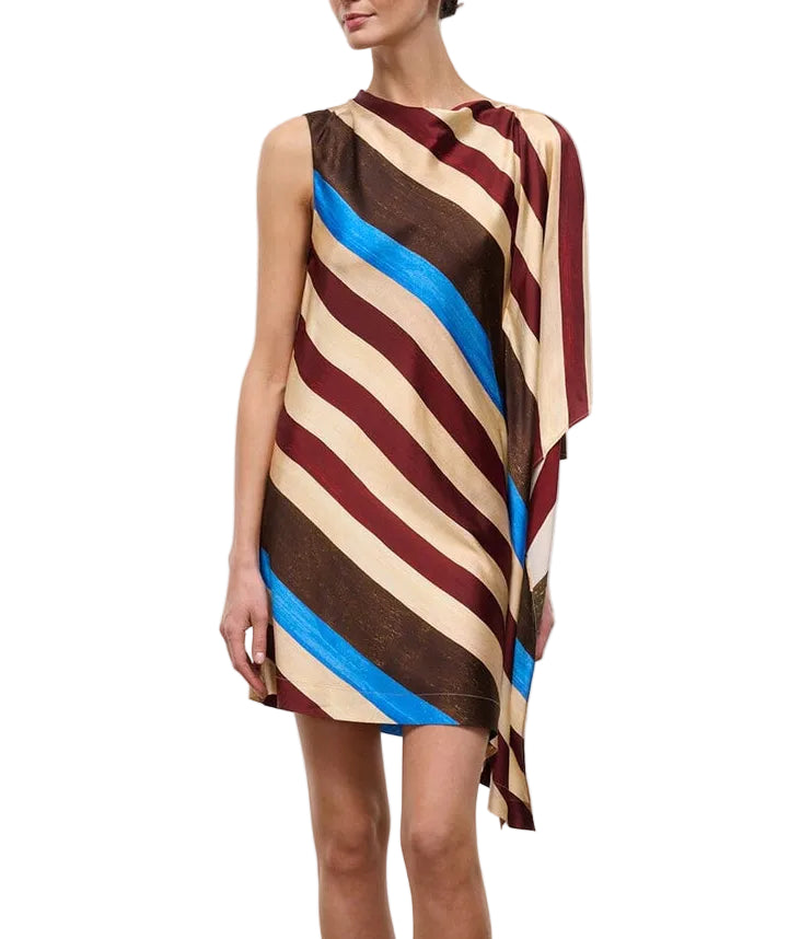 A woman wearing the Staud Sabina Silk Dress, an easy-fit column style with a sleeveless, asymmetrical silhouette and diagonal stripes in brown, cream, burgundy, and blue on printed stretch silk satin, stands against a white background.