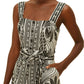 A woman radiates style in the Farm Rio Monochrome Elegance Scarf Off White Romper, confidently posing with one hand on her hip.