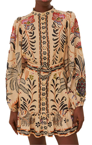 A person wearing the Farm Rio Classic Nature Sand Mini Dress from Farm Rio, which features long sleeves and showcases botanical patterns in earthy tones, complete with floral and leaf designs, and includes a knotted belt at the waist.