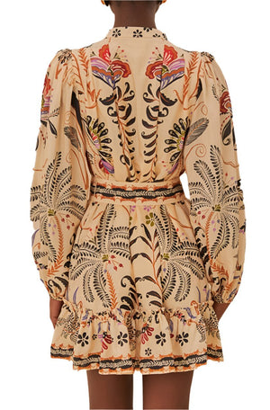 A back view of a person wearing the Farm Rio Classic Nature Sand Mini Dress by Farm Rio in earthy tones, featuring colorful botanical patterns, long sleeves, and a ruffled trim.