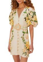 A woman wears the Farm Rio Garden Cascade Sand Mini Dress, featuring a cream floral pattern, puffed sleeves, deep V-neck, front buttons, and a wide belted waist. Made from Euroflax premium linen for chic comfort.