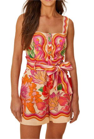 Woman wears the Farm Rio Spring Affair Beige Romper, a sleeveless LENZING™ ECOVERO™ piece featuring a colorful floral-stripe print, front buttons, and a matching waist tie for an effortlessly chic look.