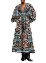 A person wears the Farm Rio Balamana Maxi Dress with voluminous sleeves, a deep V-neckline, and black heeled boots against a white background—a perfect resort-ready look.