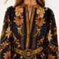 A woman wears the Majestic Garden Black Mini Dress by Farm Rio, featuring gold, orange, and cream floral patterns, a beaded buckle belt, and only part of her face visible.
