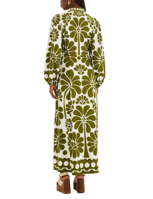 A woman is seen from the back wearing the Farm Rio Palermo Green Maxi Dress, which features buttoned puff sleeves and a green and white floral pattern, styled with platform sandals.