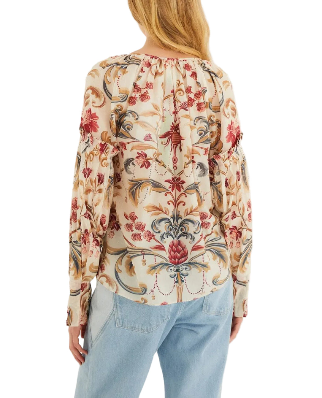 A person is shown from the back wearing a long-sleeved Farm Rio Royal Garden Sand Blouse with pastel and red floral patterns, paired with light blue jeans.