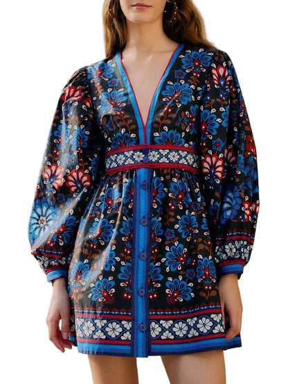 A woman wears the Farm Rio Latina Scarf Mini Dress, featuring blue, red, and white floral patterns, long puff sleeves, a deep V-neckline, and chic front buttons.