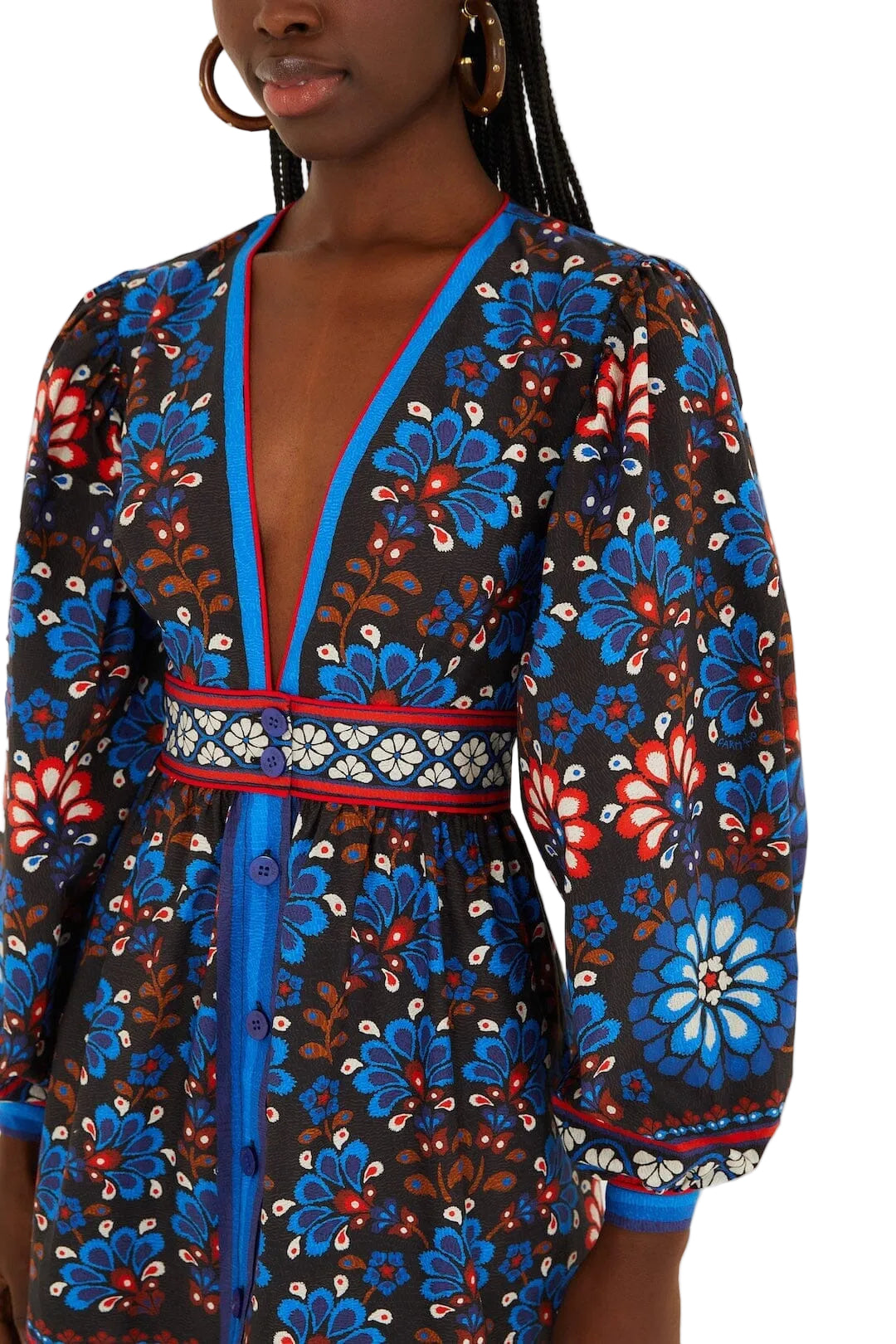 A woman wears the Farm Rio Latina Scarf Mini Dress, featuring long sleeves, a deep V-neck, and a blue, red, and white floral pattern on a dark background.