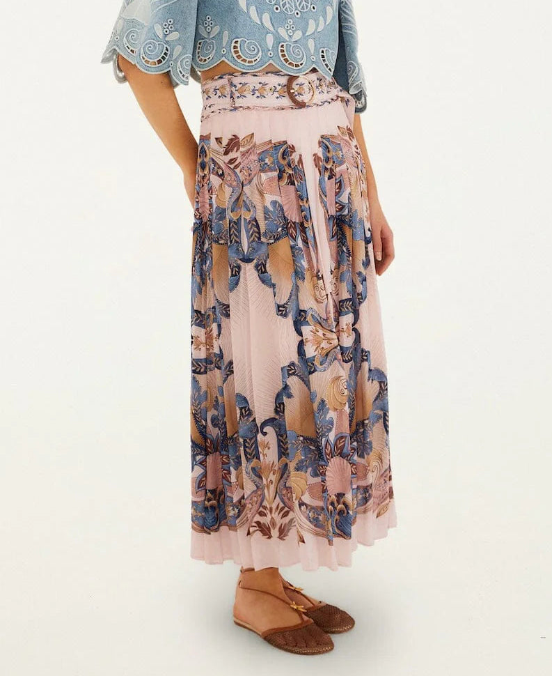 A person in a blue lace top, Sea Garden Scarf Soft Pink Maxi Skirt by Farm Rio, and brown woven flats stands against a plain background.