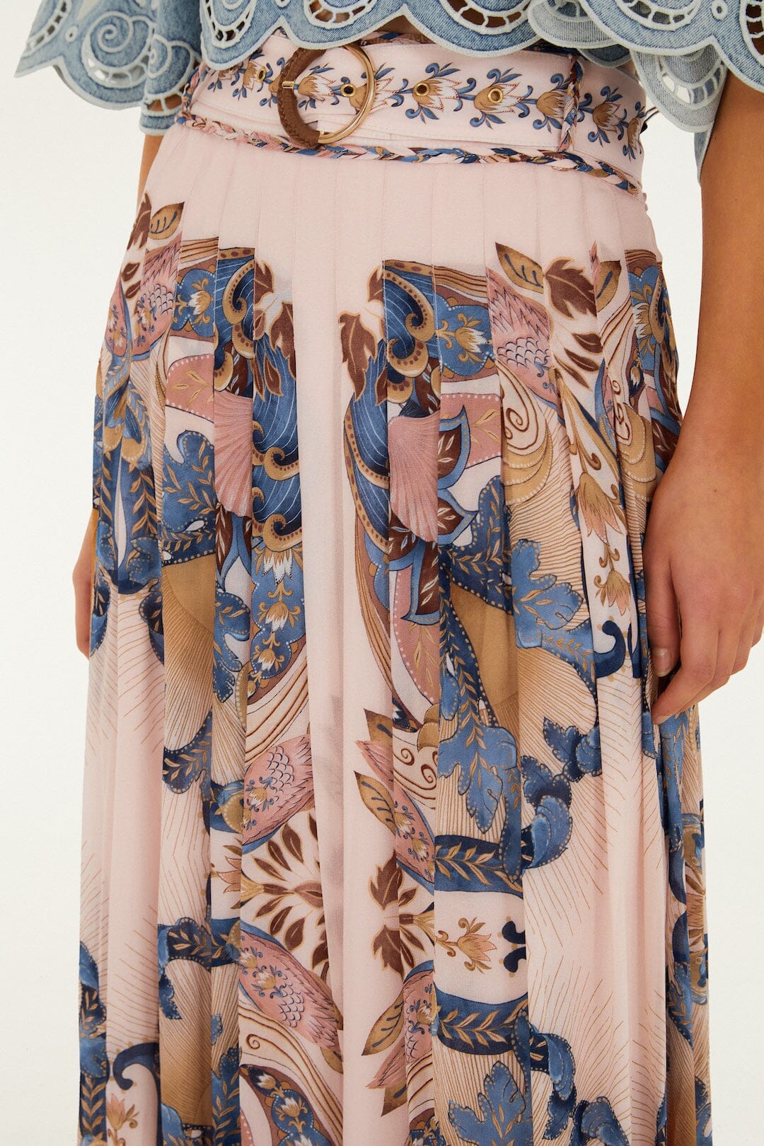 A person wears the Farm Rio Sea Garden Scarf Soft Pink Maxi Skirt, featuring a blue, pink, and brown floral and abstract print; their right hand rests by their side.
