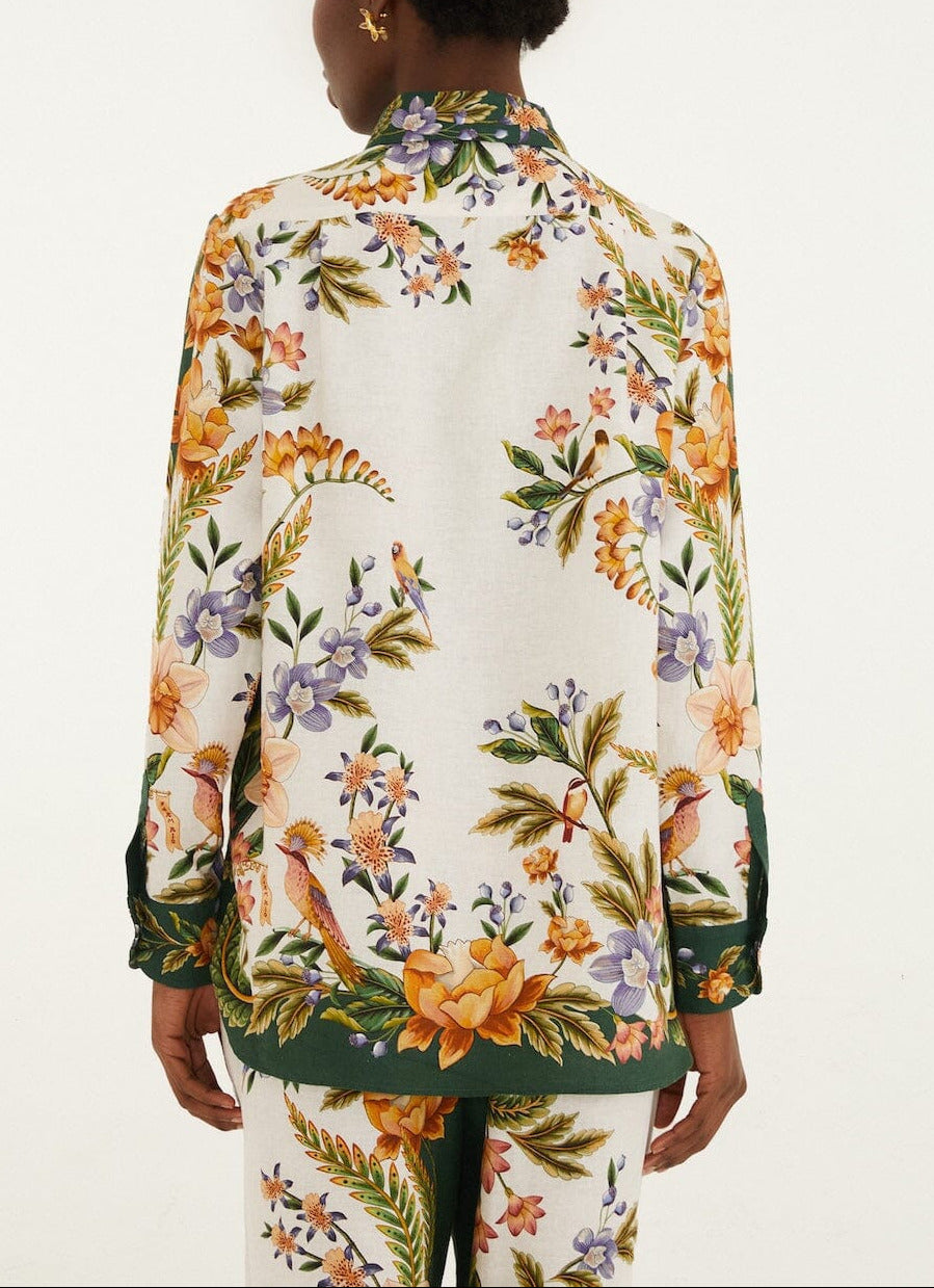 A person shown from the back wears the Farm Rio Nature Sand Shirt, a long-sleeve top with a colorful floral print and green trim, paired with matching pants against a plain background.