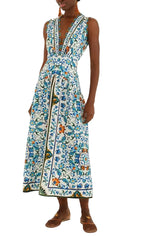 A person wears the Farm Rio Flora Tile Off White Midi Dress, which features a blue, green, and orange floral tile pattern, paired with brown flat shoes.