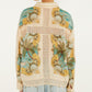 A person with short brown hair is seen from the back, wearing the Farm Rio Royal Sea Crochet Detail Shirt with tropical patterns and light blue jeans, styled with lightweight layering.