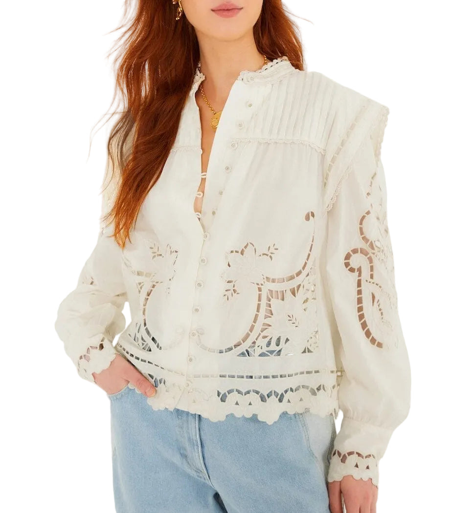 Woman wearing a Farm Rio Richilieu Blouse featuring long sleeves, a button front, embroidered cut-out details, paired with light blue jeans.