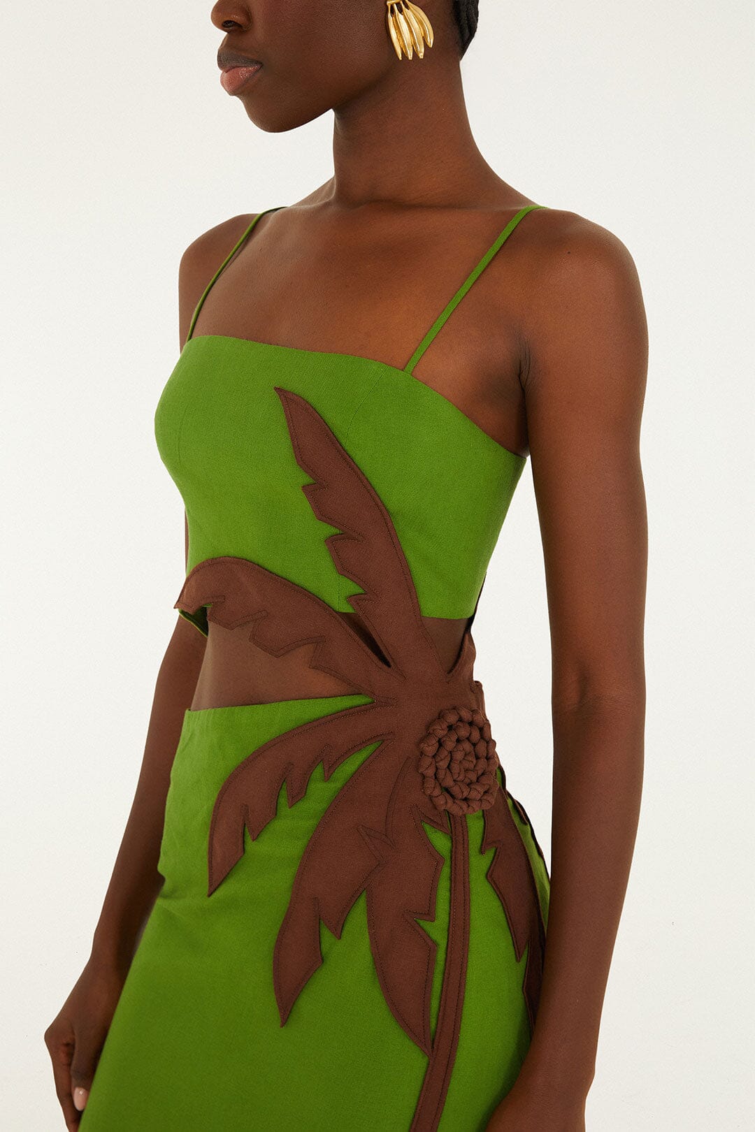 Woman wearing the Farm Rio Green Palm Tree Maxi Dress, a sleeveless tropical dress with thin straps and a palm tree detail, standing against a plain background.