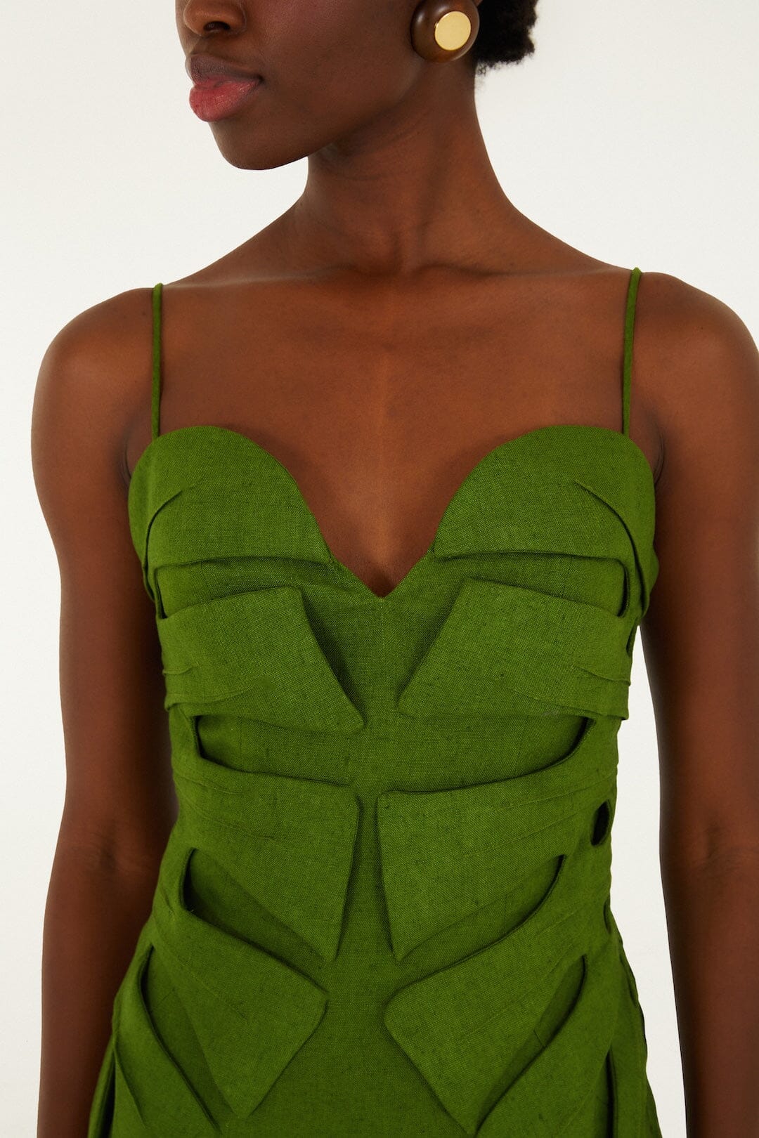 A person wears the Farm Rio Green Monstera Leaf Maxi Dress, a sleeveless linen piece with thin straps and cut-out geometric patterns, shown from shoulders to waist.