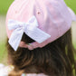 A child is seen from behind wearing the Bits & Bows Rainbow Golf Cart Bow Baseball Hat—a pastel pink girls’ accessory with a patterned bow at the back, perfect for sun-shielding sportswear.