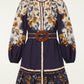 Farm Rio Golden Nature Belted Mini Dress, a long-sleeved floral mini dress with a navy bodice, button-down front, and a circular brown woven belt at the waist.