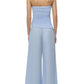 A person faces away in the Simkhai Emerson Ruched Bustier Top, a strapless light blue piece, paired with matching wide-leg striped cotton poplin pants and heels.