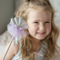 A girl smiling with a Great Pretenders Mermaid Wand in an under-the-sea setting.