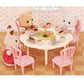 The Calico Critters Sweets Party Set features three animal figurines gathered around a table adorned with desserts, tea cups, and pastries inside a charming dollhouse setting with pink chairs, teatime accessories, and a delightful patterned wall—perfect for imaginative playtime.