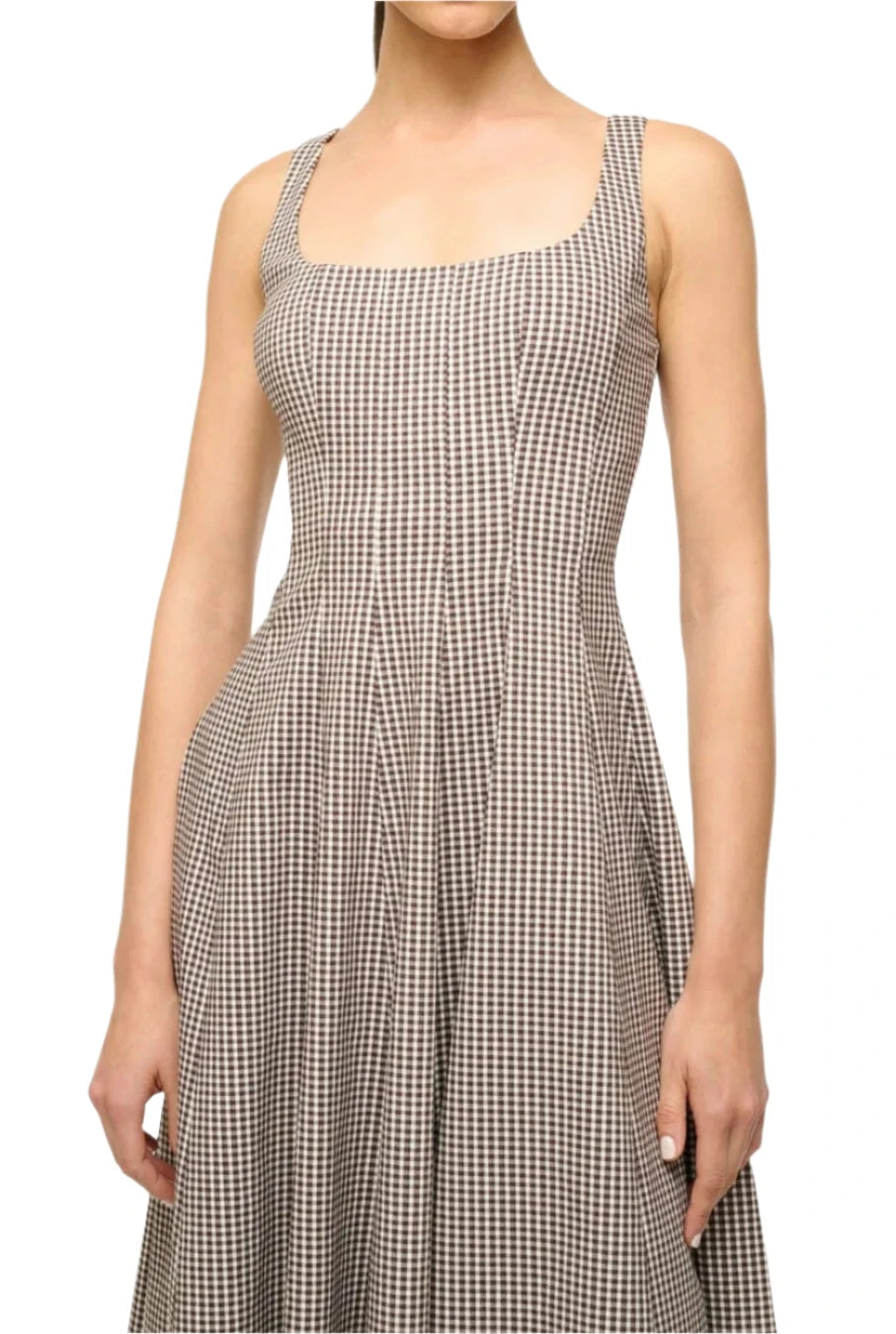 The person is wearing the Staud Wells Micro Check Dress, a sleeveless piece by Staud featuring a square neckline and corset-style design for a flattering look.