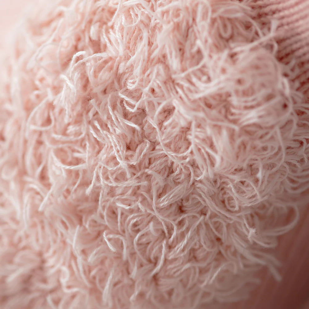 Close-up of Penelope the Flamingo - Regular 20" by Cuddle + Kind, featuring pink textured fabric with loose, looped threads that create a soft, shaggy surface reminiscent of tropical flowers.