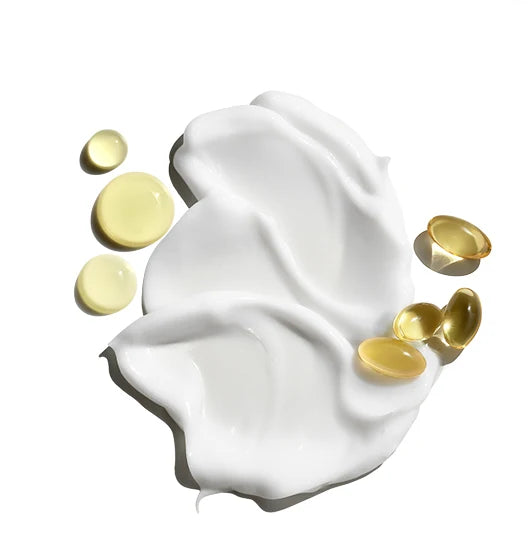 White cream, yellow liquid droplets, and yellow gel capsules—each representing Jack Black’s Cool Moisture Body Lotion—are artfully spread on a white background, evoking a fresh sensation that cools and soothes the skin.