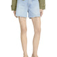 Wearing Frame's The Everyday Short in light blue, a white top, an olive green jacket, and beige low-heeled shoes, a person stands against a white background.