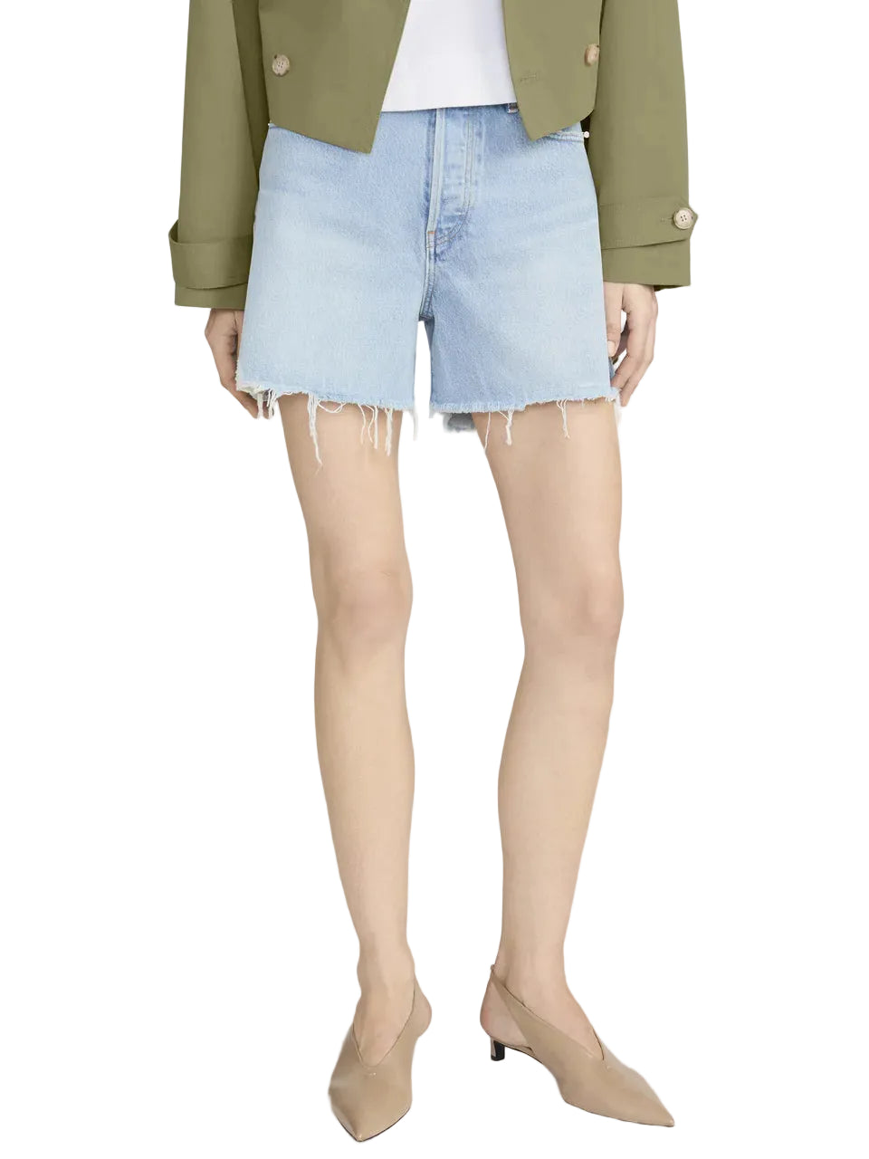 Wearing Frame's The Everyday Short in light blue, a white top, an olive green jacket, and beige low-heeled shoes, a person stands against a white background.