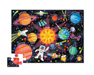 The Crocodile Creek 36 Piece Space Explorer Puzzle is a colorful jigsaw featuring labeled planets, the Sun at the center, an astronaut, a Space Explorer rocket, and stars. One piece is missing in the bottom left.
