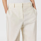 Model wears Stella McCartney Washed Cotton Straight Trousers in cream, styled with a white sleeveless top, hands in pockets, shown from waist to upper thighs.