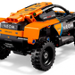 A black and orange LEGO® Technic™ NEOM McLaren Extreme E Race Car by Legos - Toyhouse, featuring sponsor logos, is shown from the rear on a white background.