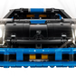 Front view of the LEGO® Technic™ Porsche GT4 e-Performance Race Car by Legos - Toyhouse, a black and blue remote-controlled model with headlights on, detailed grille, and Porsche badge on the hood, set against a white background.