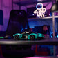 A LEGO® Technic™ Aston Martin Valkyrie by Legos - Toyhouse sits on a desk in a modern workspace with neon lighting and shelves in the background.