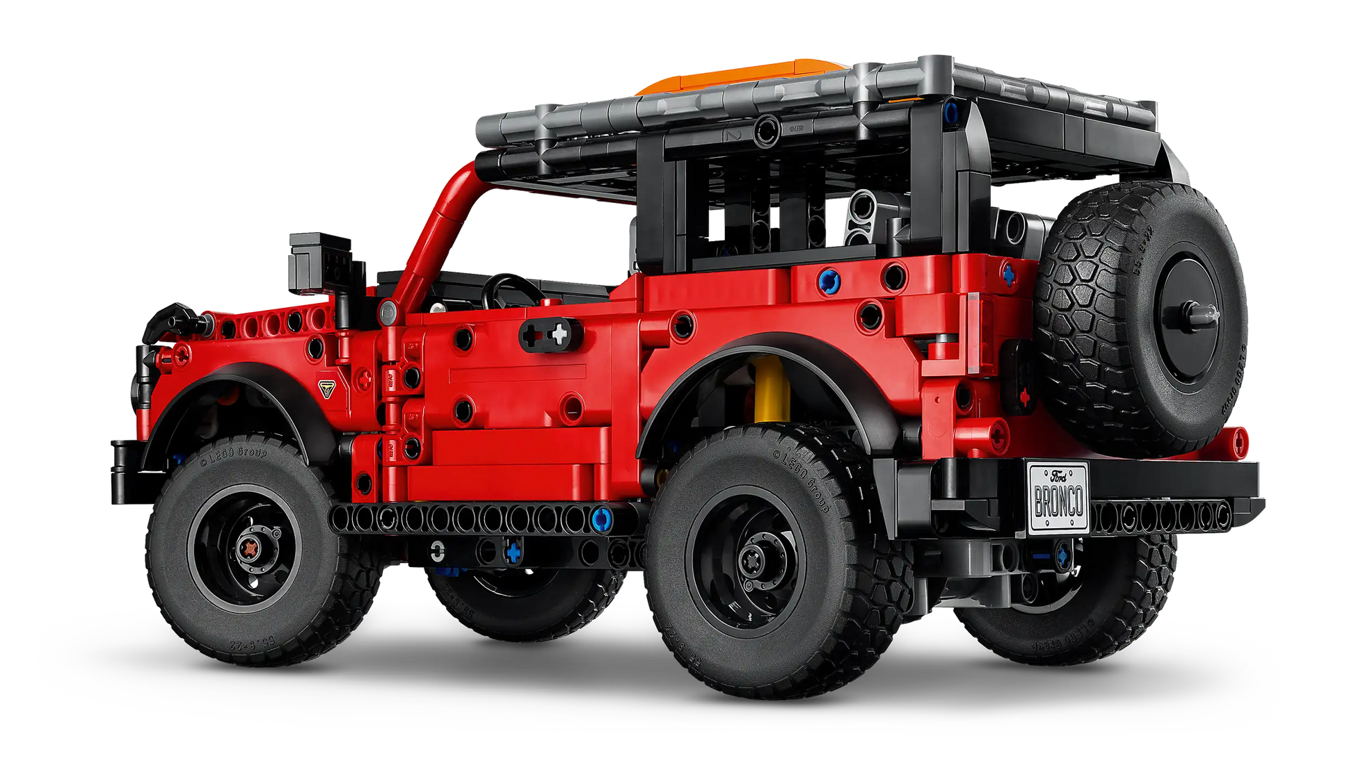 A LEGO® Technic™ Ford Bronco® SUV by Legos - Toyhouse, featuring a red off-road design with a rear spare tire and exposed building parts, shown against a white background.