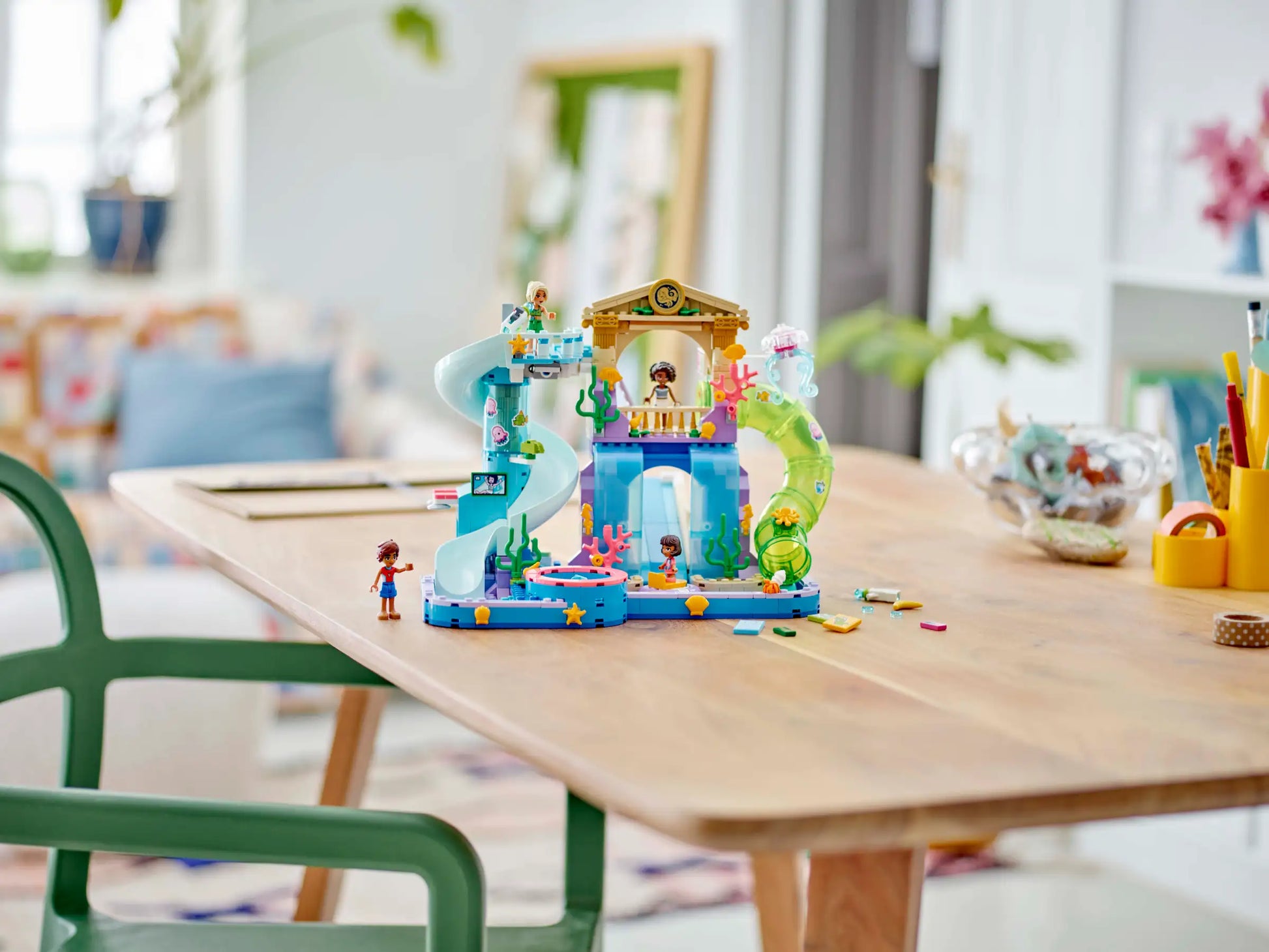 The Legos - Toyhouse LEGO® Friends Heartlake City Water Park playset, complete with slides and mini-figures, is assembled on a wooden table in a bright room—an ideal role-playing toy for kids.