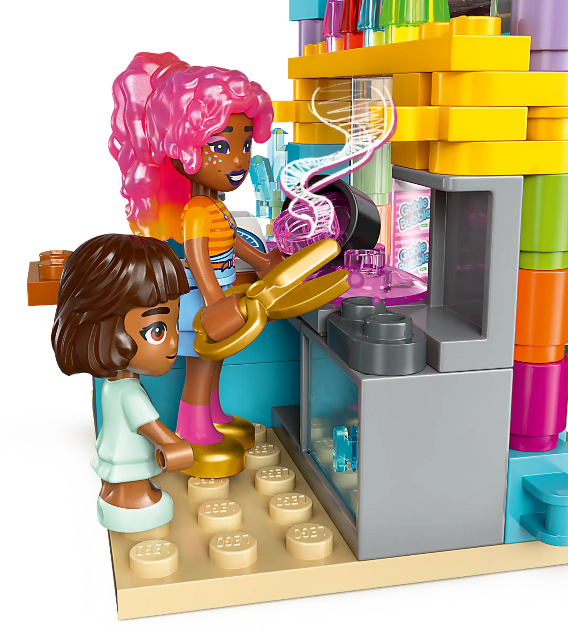 Two LEGO minifigures stand outside the vibrant LEGO® Friends Heartlake City Candy Store by Legos - Toyhouse, with one holding tongs near a swirling pink treat—ideal for shop toy fans and creative builders.