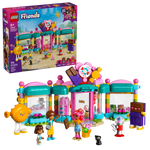 The LEGO® Friends Heartlake City Candy Store by Legos - Toyhouse includes a colorful bakery, four mini-doll figures, two large character figures, a black cat figure, and fun accessories; packaging appears in the background.