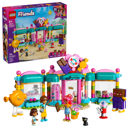 The LEGO® Friends Heartlake City Candy Store by Legos - Toyhouse includes a colorful bakery, four mini-doll figures, two large character figures, a black cat figure, and fun accessories; packaging appears in the background.