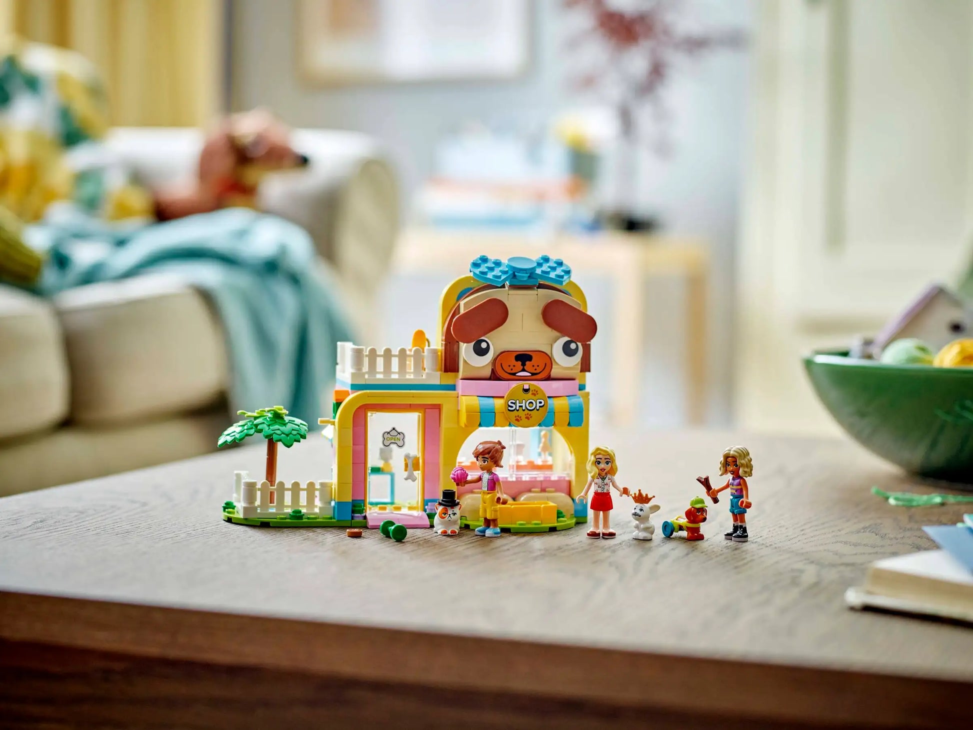 The LEGO® Friends Pet Accessories Shop by Legos - Toyhouse features a colorful animal-themed shop, perfect for animal-care pretend play, and includes three mini-figures plus several small animal figures displayed on a wooden table.