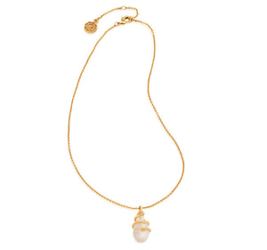 The Lily Charm Necklace by Juliska Capucine De Wulf features a delicate chain with a white pearl pendant, gold accent, adjustable clasp, and a small round charm near the closure.