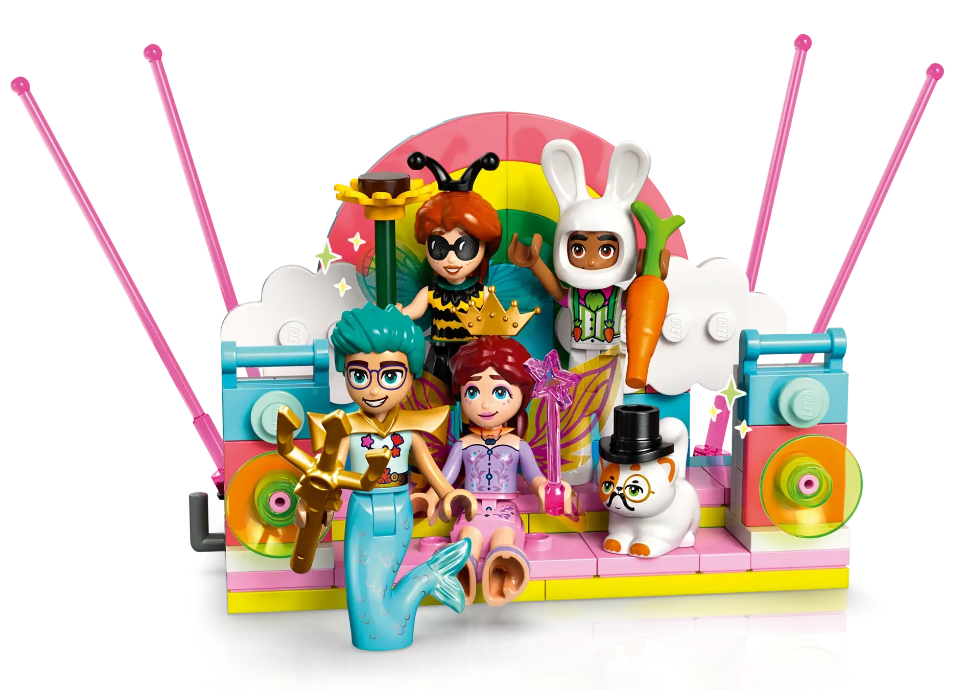 Four LEGO minifigures in colorful costumes and a snowman stand on a vibrant stage with pink antennas, rainbow backdrop, and musical details—perfect for pretend play with the LEGO® Friends Costume Party with Unicorn & Fairy by Legos - Toyhouse.