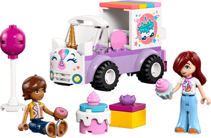 Two toy figures with desserts sit by the Legos - Toyhouse LEGO® Friends Unicorn Cake Delivery Car, featuring a unicorn design, cake, cupcake, and present—ideal for unicorn toy fans and creative building fun.