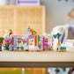 The LEGO® Friends Unicorn Dream Café by Legos - Toyhouse is shown on a table with school supplies—a vibrant building set featuring mini-figures for imaginative unicorn café play.