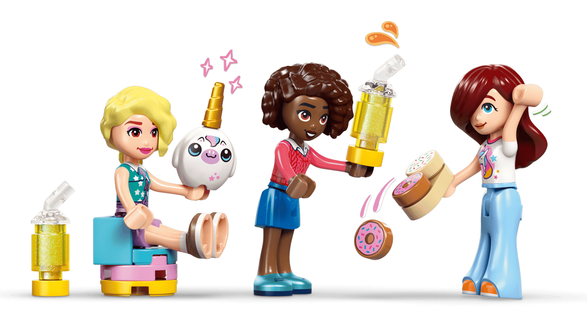 At the Legos - Toyhouse LEGO® Friends Unicorn Dream Café, one mini-figure sits with a unicorn, another stands holding a trophy, and a third raises an arm while holding a plate of donuts.