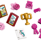 Assorted LEGO accessories inspired by the LEGO® Friends Horse Stable and Riding Academy from Legos - Toyhouse, including two illustrated books, a trophy, flower, ribbon, comb, hair bow, cupcake, and instruction sheet.