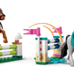 Two LEGO® Friends figures from Legos - Toyhouse jump horse toys over colorful brick fences with pink flags, recreating the vibrant equestrian scene of the LEGO® Friends Horse Stable and Riding Academy set.