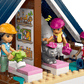 Three LEGO® figures with helmets enjoy pretend play with a gray cat and a tan dog inside a roofed Horse Stable—ideal for any horse lover or fan of the LEGO® Friends Horse Stable and Riding Academy by Legos - Toyhouse.